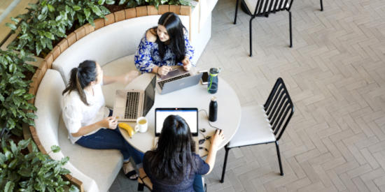 A top-down view of an indoor office breakout area at Festival Tower, surrounded by green potted plants.